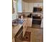 Bright kitchen with white cabinets, stainless steel appliances, and tile flooring for easy maintenance at 527 San Pedro Dr, The Villages, FL 32159