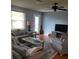 Cozy living room features hardwood floors, ceiling fan, and comfortable gray sofa and armchair at 527 San Pedro Dr, The Villages, FL 32159