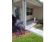 Cozy covered porch with a decorative leaded glass front door and tidy landscaping at 527 San Pedro Dr, The Villages, FL 32159