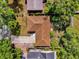 Aerial view of a single-story home with a brown roof, driveway, surrounded by trees and grass at 5806 Fernhill Dr, Orlando, FL 32808