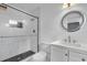 Bathroom features white marble tiled shower and decorative mirror above a white vanity at 5806 Fernhill Dr, Orlando, FL 32808