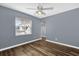 Cozy bedroom with hardwood floors, a ceiling fan, and a bright window at 5806 Fernhill Dr, Orlando, FL 32808