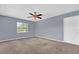 Bedroom with neutral carpet, blue walls, ceiling fan, and a bright window at 5806 Fernhill Dr, Orlando, FL 32808