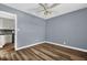 Bedroom featuring hardwood floors, updated ceiling fan, and doorway to the kitchen at 5806 Fernhill Dr, Orlando, FL 32808