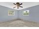 Bedroom featuring tile flooring, ceiling fan, and two bright windows at 5806 Fernhill Dr, Orlando, FL 32808