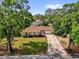 Charming single-story home with a well-manicured lawn and mature trees lining the property at 5806 Fernhill Dr, Orlando, FL 32808