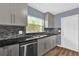 Well-lit kitchen with a stainless steel dishwasher, tile backsplash, and sleek countertops at 5806 Fernhill Dr, Orlando, FL 32808