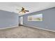 Bright living room featuring neutral carpet, ceiling fan, and a large window at 5806 Fernhill Dr, Orlando, FL 32808