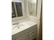 Bathroom vanity with white countertop, sink, framed mirror, and storage at 804 Maple Ln, Lady Lake, FL 32159