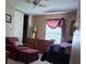 Comfortable bedroom featuring a bed with a quilt, chair, and ample natural light at 804 Maple Ln, Lady Lake, FL 32159