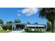 Charming single-story home with blue and white trim, lush landscaping, and a screened front patio at 804 Maple Ln, Lady Lake, FL 32159