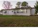 Single-wide mobile home with a large window and grassy yard at 4775 Hunting Lodge Dr, Saint Cloud, FL 34772