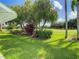 Landscaped backyard with lush greenery and golf course view at 235 Anastasia Dr, Poinciana, FL 34759