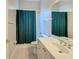 Clean bathroom with shower/tub combo, vanity, and green shower curtain at 235 Anastasia Dr, Poinciana, FL 34759