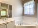 Bathroom with double vanity, bathtub, and shower at 235 Anastasia Dr, Poinciana, FL 34759