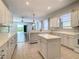 Kitchen features white cabinets, island, and views to Gathering room at 235 Anastasia Dr, Poinciana, FL 34759