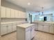 Eat-in kitchen with white cabinets and kitchen island at 235 Anastasia Dr, Poinciana, FL 34759