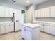 White kitchen features an island and stainless steel appliances at 235 Anastasia Dr, Poinciana, FL 34759