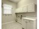 Laundry room with white cabinets and tile floor at 235 Anastasia Dr, Poinciana, FL 34759