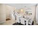 Elegant dining room with a white table, chandelier, and stairs leading to the upper level at 5144 Oakbourne Ave, Davenport, FL 33837