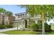 Two-story house with a green facade, red door, and well-maintained landscaping at 5144 Oakbourne Ave, Davenport, FL 33837