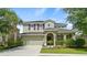 Two-story house with a green exterior, attached garage, and manicured landscaping at 5144 Oakbourne Ave, Davenport, FL 33837