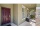 Covered front porch with a dark-red door and stone accents at 5144 Oakbourne Ave, Davenport, FL 33837