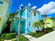 Two-story light teal home with yellow and green neighbors, palm trees, and a sidewalk at 2968 Salted Rim Rd, Kissimmee, FL 34747