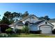 Two-story house featuring a gray roof, white exterior, and lush landscaping at 2863 Picadilly Cir, Kissimmee, FL 34747