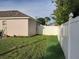 Side yard view showing a grassy area and white fence at 924 Derbyshire Dr, Kissimmee, FL 34758
