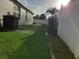 Side yard with artificial turf and a white vinyl fence at 924 Derbyshire Dr, Kissimmee, FL 34758