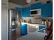 Bright kitchen with blue cabinets and stainless steel appliances at 924 Derbyshire Dr, Kissimmee, FL 34758