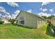 Spacious backyard with a bright green lawn and large picture windows looking into the home at 705 Ashton Dr, Davenport, FL 33837
