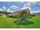 Home's exterior surrounded by mature landscaping, lush grass, and blooming flowers in the front yard at 705 Ashton Dr, Davenport, FL 33837