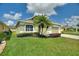 Well-maintained home exterior featuring lush green lawn, mature landscaping, and a two-car garage at 705 Ashton Dr, Davenport, FL 33837