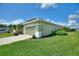 Home exterior featuring a two car garage, mature landscaping, and a green lawn at 705 Ashton Dr, Davenport, FL 33837