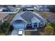 Aerial view of a home with a well-maintained roof, driveway, and lush landscaping in a residential neighborhood at 959 Nancy Ct, Kissimmee, FL 34759