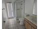 Bathroom features tiled flooring, frosted glass shower stall, toilet, sink, and door with window at 959 Nancy Ct, Kissimmee, FL 34759