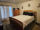 Cozy bedroom featuring a wood bed frame, neutral walls, and natural light from the window at 959 Nancy Ct, Kissimmee, FL 34759