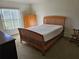 Bedroom with a wooden bed frame, a window with blinds, and a dresser with drawers at 959 Nancy Ct, Kissimmee, FL 34759