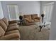 Cozy living room featuring neutral-toned furniture, glass-topped tables, and natural light from window blinds at 959 Nancy Ct, Kissimmee, FL 34759