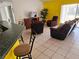 Bright living room with yellow accent wall, tile flooring, and comfortable brown furniture at 959 Nancy Ct, Kissimmee, FL 34759