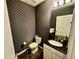 Dark-wallpapered half-bath with black granite vanity at 2755 Monticello Way, Kissimmee, FL 34741