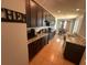 A long view of the kitchen with dark cabinetry and granite countertops, flowing into a dining area at 2585 Needlepoint St, Kissimmee, FL 34741