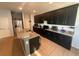 Modern kitchen with sleek black cabinetry, granite countertops, and stainless steel appliances at 2585 Needlepoint St, Kissimmee, FL 34741