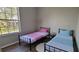 Shared bedroom with twin beds, minimalist decor, and a large window offering natural light and neighborhood views at 2307 Butterfly Palm Way # 201, Kissimmee, FL 34747