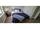 Cozy bedroom with a comfortable bed, wood-look flooring, and natural light from the large window at 2307 Butterfly Palm Way # 201, Kissimmee, FL 34747