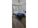 Sunlit bedroom with a dark comforter and wood-look flooring, showcasing a minimalist design and natural light at 2307 Butterfly Palm Way # 201, Kissimmee, FL 34747