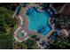 Aerial view of sparkling community pool surrounded by lounge chairs and lush greenery at 2307 Butterfly Palm Way # 201, Kissimmee, FL 34747