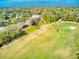 Aerial view showcasing a golf course and beautiful homes surrounded by lush greenery and mature trees at 441 Mayfair Dr, Kissimmee, FL 34759